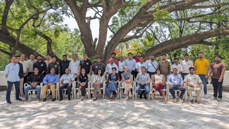 Coursera Udemy merger Bangalore instructor summit group photo under the rain tree at the venue